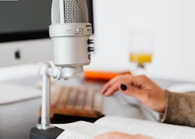 Hands holding a book near a microphone, perfect for recording or podcast scenes.